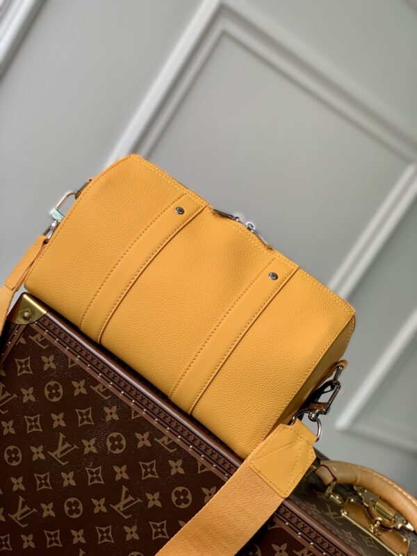 💰City Keepall 手袋 M21438 （59255）黑色男装艺术总监 Virgil Abloh 重新设计经典手袋 创造了本款男士 City Keepall 手袋 由黑色粒面皮革制成 细节设计采用黑白 Damier Distorted 帆布打造 饰有橘黄色 L*首字母标识 。尺寸：27 × 17× 13 厘米。