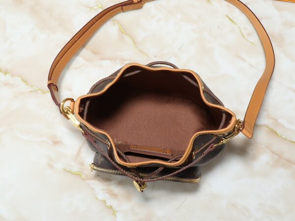 i1740335079_5449_1.jpg 升级原版 M14199 M14017 Noe Cargo 是一款小巧的水桶包,由亮面牛皮革构型,呈现尼龙般的科技感光泽,内衬采用深沉色调织物。金属件,包括连接在球形链条上的LV字母在内,成为这款单色手袋上的唯一色彩调和元素。内设宽敞前袋。·牛皮革饰边织物内衬金属件抽绳和金属开合主隔层LV吊坠拉链头●珍珠铆钉Louis Vuitton Paris 贴饰·拉链前袋肩带: