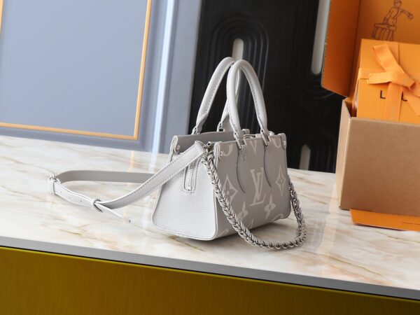 💰升级原版 M14213 M14236 M46653 本款 OnTheGo East West 手袋出自 LV Milky Way 系列，为标志性 Monogram Empreinte 皮革渲染当季色彩，与亮泽金属件和可拆卸编织链条交相辉映。内外隔层可有序收纳日常所需，紧凑构型方便以多种方式背携。尺寸:25.0 x 13.0 x 10.0 厘米 (长 x 高 x 宽)